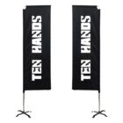 Two black vertical banners with white text that reads TEN HANDS. The banners are mounted on metal stands with a cross-shaped base.