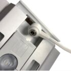 Close-up of a white charging connector plugged into a white electronic device. The device has a label showing input specifications IN DC24V, and a round protruding part with a translucent cover.