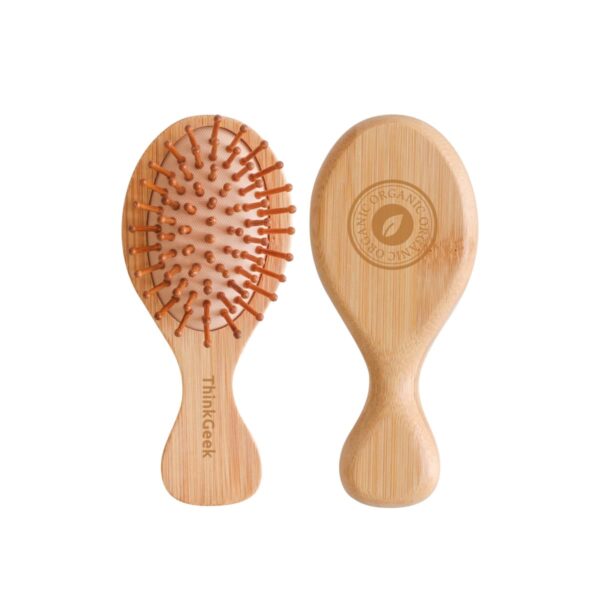 Two small wooden hairbrushes with rounded handles. One brush shows its bristle side with orange bristles, while the other shows its smooth back with a circular engraved logo and text on it.