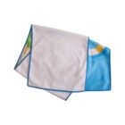 A folded rectangular towel with a white side and a colorful print partially visible, featuring blue, yellow, and green accents along the edges. Blue stitching lines the border of the towel.
