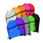 A collection of nine drawstring bags in various colors, including white, yellow, orange, pink, blue, purple, gray, green, and black. Each bag has a black drawstring and black eyelets.