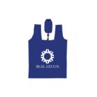 A blue reusable shopping bag with a geometric star-like logo in white and the text REAL ESTATE underneath. The bag has a small attached pouch for compact storage.
