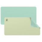 A rectangular, reversible desk mat in light aqua and pastel yellow is shown. The corner is flipped to display both colors. Theres a subtle logo on the bottom left corner.