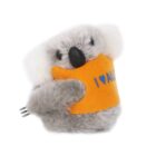 A plush koala toy wearing an orange vest with I ♥ AUS printed on it. The koala has grey fur, a black nose, and white fluffy ears, holding a small plastic fork on its side.