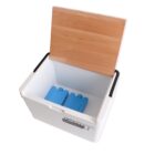 An open white cooler with a wooden lid partially covering it. Inside are two blue ice packs. The cooler has black handles on the sides.