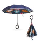 A blue umbrella with a unique inverted design, featuring colorful cartoon animal faces on the inside. The handle is shaped like a hook, and a separate image shows the umbrella folded, highlighting the vibrant interior pattern.