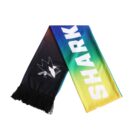 A colorful scarf with a gradient from blue to yellow. One end features a stylized shark logo in black and white, and the other end has the word SHARKS in bold white letters. Black fringe decorates the edge.