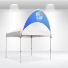 A white popup canopy tent with a blue half-circle banner that reads BIG SALE 25% OFF in white and red lettering is set up in a well-lit space with white walls and a high ceiling.