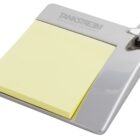 A silver metallic note holder with a pad of yellow sticky notes. It has a bottle opener on the top right corner and the text TANKSTREAM BEVERAGE COMPANY engraved on the top.