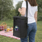 Woman carrying Multi Printed Cooler Bags near a picnic setup on grass in a park.