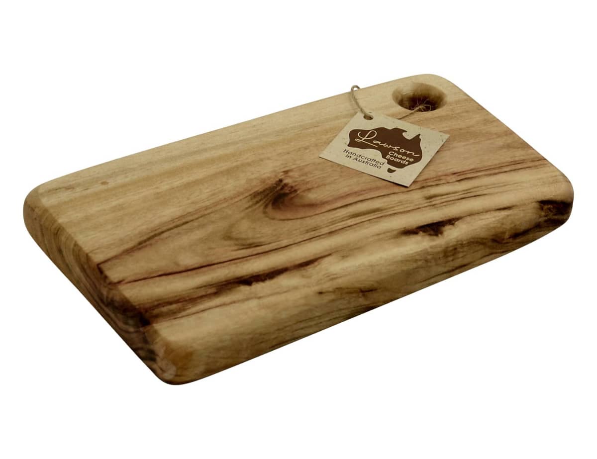 A rectangular wooden cutting board with a smooth surface and visible grain patterns. It has a hole in one corner with a tag attached. The tag displays text and an outline of a map.