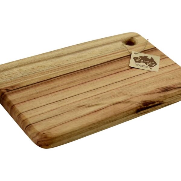 A rectangular wooden cutting board with a smooth finish and rounded edges. It has a small hole in one corner with a tag attached. The board displays natural wood grain patterns.