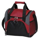 A red and black insulated lunch bag with a zippered front pocket, gray accents, and black handles. The bag is rectangular with a top handle and an adjustable shoulder strap.