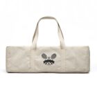 A rectangular beige canvas bag with two handles is shown. It features a printed design of two overlapping tennis rackets and a triangle with a circular emblem above, all in black.