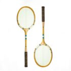 Two vintage wooden tennis rackets with light-colored strings and patterned grips are arranged on a white background. One racket is shown front-facing, and the other is positioned sideways.