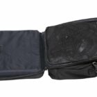 Open black backpack displaying a section with a laptop compartment and a mesh pocket containing cables. The bag is unzipped, revealing organized interior storage.