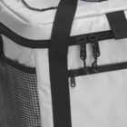 A gray insulated cooler bag with black zippers and a mesh side pocket. It features adjustable black straps for carrying. The top appears cushioned and includes additional cords for securing items.