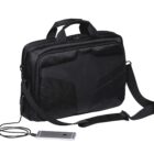 A black laptop bag with a padded design and multiple compartments. It features a shoulder strap and two top handles. An external power bank is connected to a smartphone via a charging cable, indicating built-in charging capabilities.