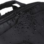 Close-up of a black bag with water droplets on its surface, showcasing its water-resistant material. The image highlights the bags zippers and textured fabric.
