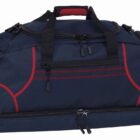 A navy blue duffel bag with red accents and black zippers is shown. The bag has multiple compartments, including a large main section and side pockets, with sturdy black handles and a red padded grip.