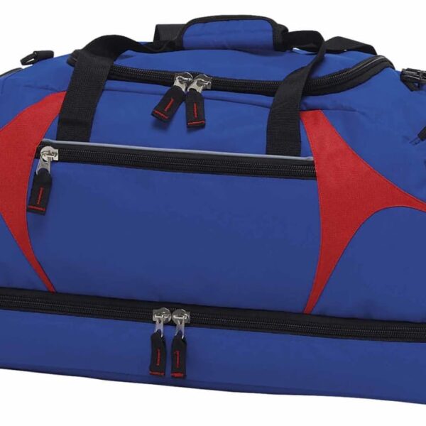 A blue duffel bag with red accents and black handles. It features multiple zippered compartments, including a main section and a lower compartment with two zippers.