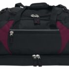 A black and burgundy duffel bag with multiple zippered compartments and handles, designed for travel or sports use.