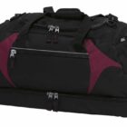 A black duffel bag with dark red accents and multiple compartments, including zippered pockets and handles.