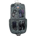 An open garment bag hanging upright, containing belts, ties, cufflinks, a watch, socks, and black dress shoes. The bag is neatly organized with items arranged in separate compartments.