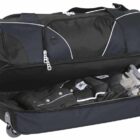 A large black wheeled duffel bag with a zippered top compartment, partially open to reveal neatly packed clothes and shoes inside. The bag has carrying handles and appears sturdy for travel.