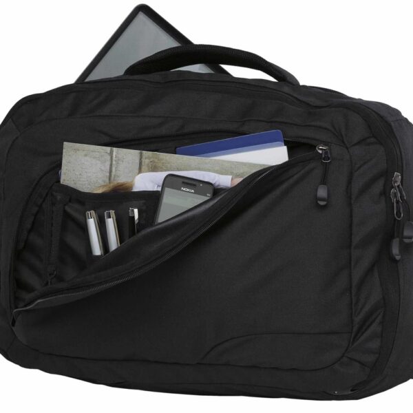 A black backpack with an open front pocket revealing two pens, a mobile phone, a notebook, and a brochure. The main compartment is partially open, showing a laptop. The bag has zippers and a top handle.