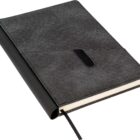 A closed hardcover notebook with a dark gray fabric cover and a black leather spine. It features a built-in pen holder and a black ribbon bookmark. The pages appear thick and cream-colored.