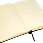 An open notebook with lined, cream-colored pages and a black ribbon bookmark laying on a white surface. The notebook is blank, ready for writing or drawing.