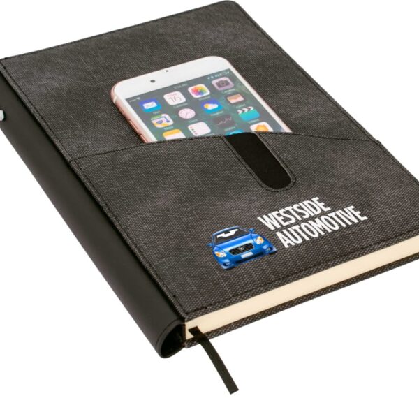 A black notebook with a pen attached to its spine. The cover has a pocket holding a smartphone with app icons visible. The logo Westside Automotive with a blue car graphic is printed on the cover.