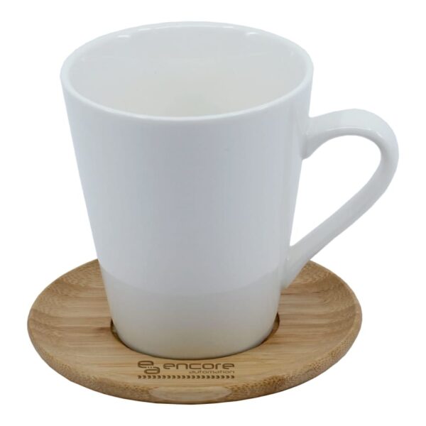 A white ceramic mug resting on a round bamboo coaster; the coaster has the word encore engraved on it.