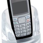 A classic mobile phone with a keypad in a transparent stand. The stand has homehouse REAL ESTATE ADVICE printed on it.