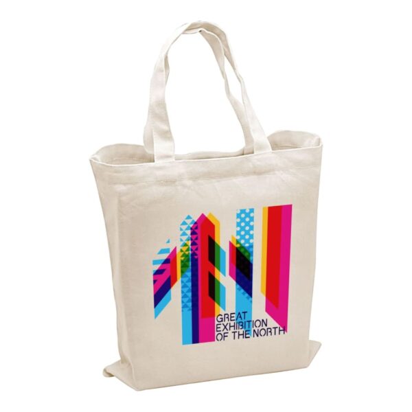 Canvas tote bag with colorful geometric design and text that reads Great Exhibition of the North. The design features vertical stripes in shades of pink, blue, and green.