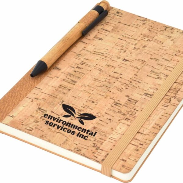 Cork-covered notebook with a pen attached to the spine. The cover features the logo and text environmental services inc with a leaf motif. An elastic band secures the notebook, and a ribbon bookmark is visible.