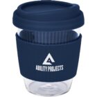 A reusable glass coffee cup with a navy blue silicone lid and sleeve. The sleeve features a logo with a triangle and the text Ability Projects. The cup has a ribbed design for grip.