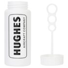 White bubble solution bottle with HUGHES AIRCRAFT COMPANY text in black. The cap is open, revealing a bubble wand with three loops lying next to the bottle. The design is simple and monochrome.