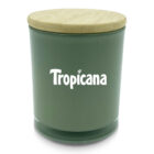 A green glass jar with a wooden lid, featuring the word Tropicana in white text on its front.