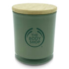 Green candle jar with a wooden lid featuring the logo of The Body Shop on the front.