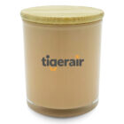 A beige cylindrical candle with a wooden lid. The word tigerair is printed in gray and orange letters on the front.