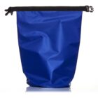 A blue waterproof dry bag with a black roll-top closure and buckle. The bags surface is smooth and slightly crinkled, reflecting light. The closure strap is cinched tightly at the top.