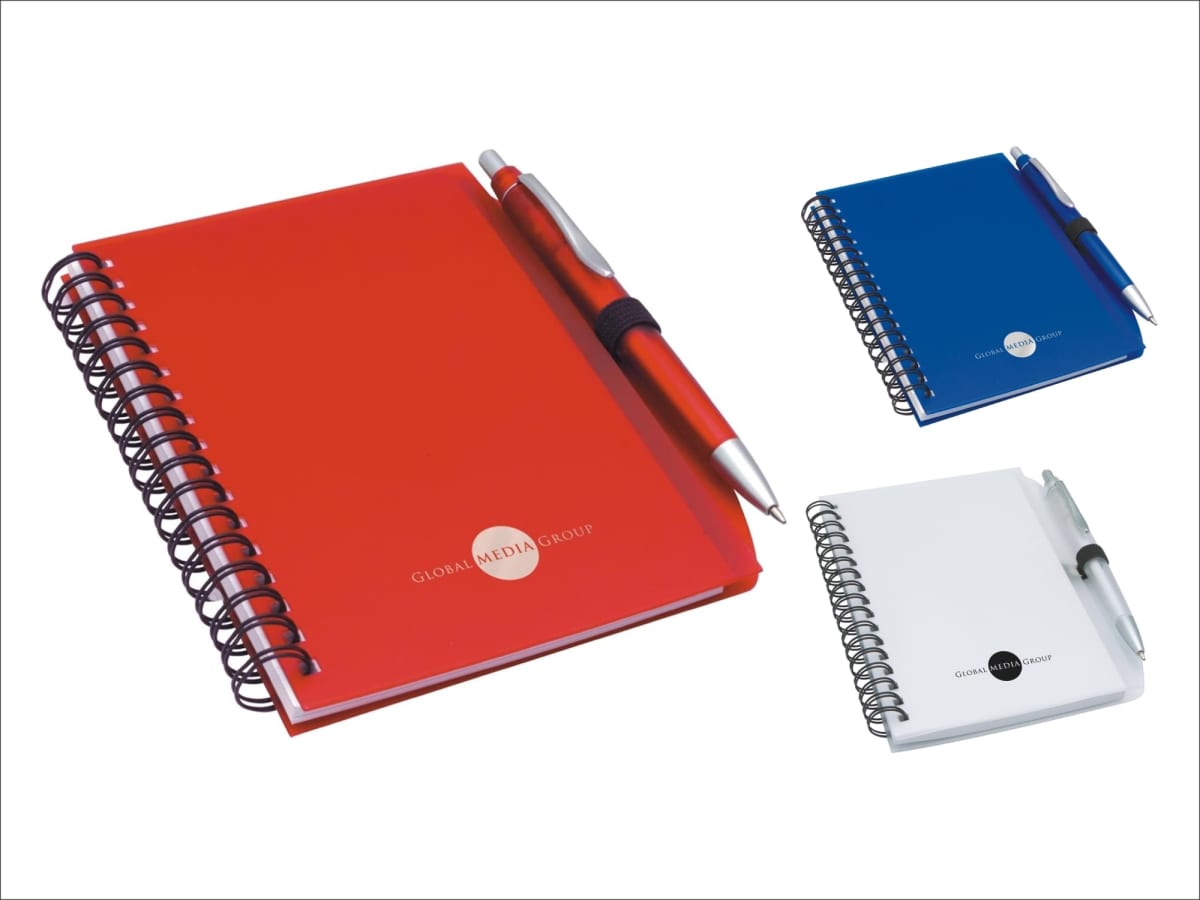 Three spiral-bound notebooks with attached pens: one red, one blue, and one white. Each has a Global Media Group logo on the cover. The pens are inserted in elastic loops on the left side.