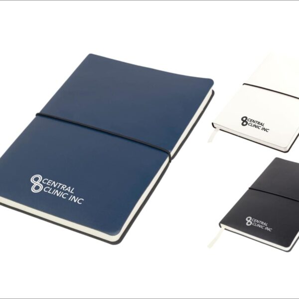 Three notebooks are displayed: one large blue with a white bookmark, and two smaller black and white versions. Each has Central Clinic Inc printed on the cover, and all are closed with black elastic bands.