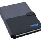 A closed gray and black notebook with a strap closure and Stanway logo in blue on the cover. The notebook has a fabric-like texture on one half and a smooth, leather-like finish on the other.