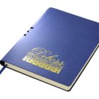 A blue notebook with gold embossed text Deboss The Premier Option on the cover. It has a blue ribbon bookmark and is shown slightly open, revealing white pages.