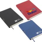 Three closed notebooks are displayed. One is red with a colorful logo, and the other two are black and blue, each with a white logo for Helix Capital.
