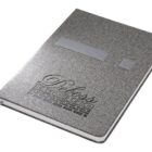 A gray notebook with textured fabric cover and a ribbon bookmark. The cover features the text Bliss: The Premier Option embossed in stylized font.