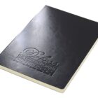 A black notebook with a textured cover and embossed lettering that reads Deloss The Premier Option. The notebook is closed and shown from an angled top view, highlighting its sleek design and cream-colored pages.